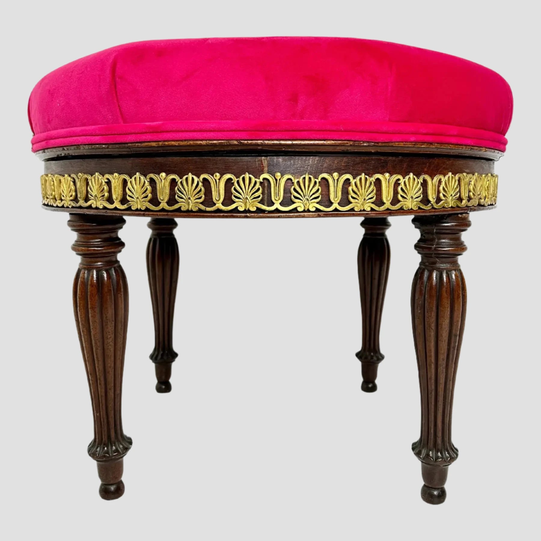 Decorative stool with pink cushion, gold detailing, and wooden legs