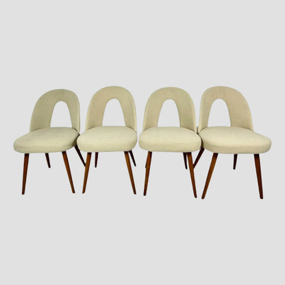 Four beige chairs with wooden legs