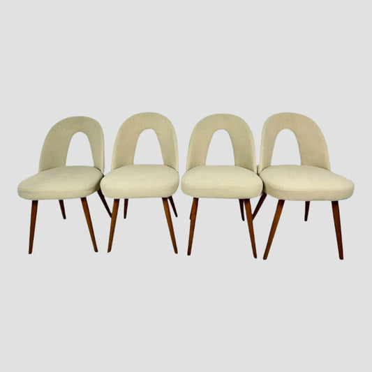 Four beige chairs with wooden legs