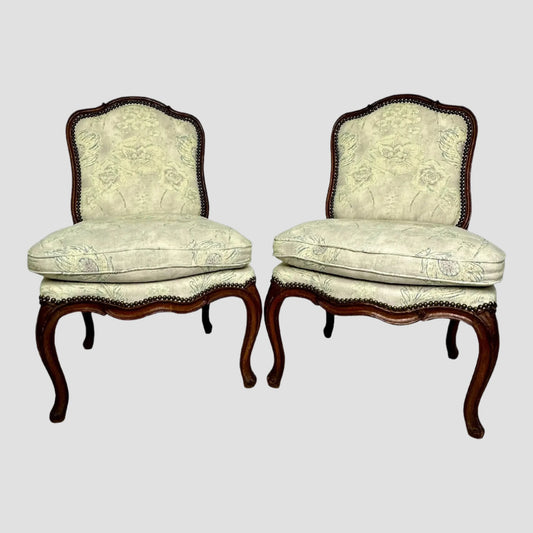 Pair of ornate chairs with floral upholstery on a white background